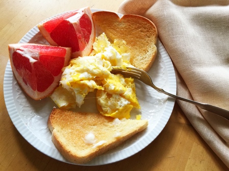 breakfast of toast, scrambled eggs and grapefruit