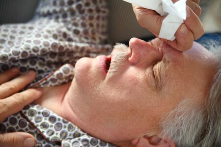 Older man suffering from the miseries of an upper respiratory infectionの写真素材