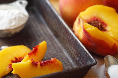 Fresh peaches sliced into a vintage pan with sugar and flourの写真素材