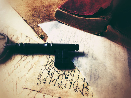 Large key on old papers with leather-covered vintage bookの写真素材