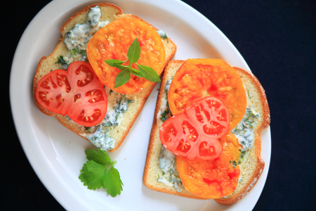 Tomato sandwich with heirloom tomatoes with cilantro mayonnaise on a white platterの写真素材