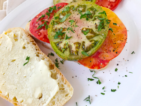 Three kinds of heirloom tomatoes with mayonnaise on crusty breadの写真素材