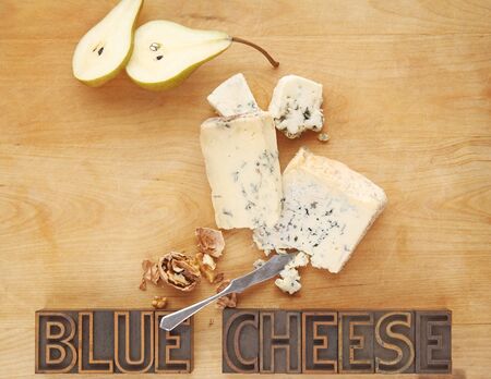 Blue cheese pieces with fresh pear, walnuts, and the words on a cutting board with copy spaceの写真素材