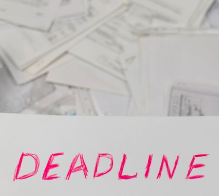 Deadline is written on paper in red on the background of blurry documents.  の写真素材
