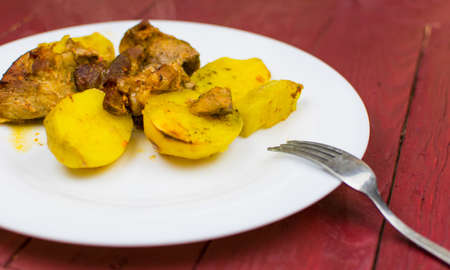 Baked potatoes with meat on a white plate.の写真素材