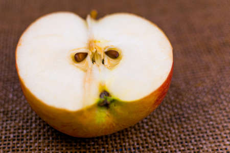 Half an apple on a dark brown background.の写真素材