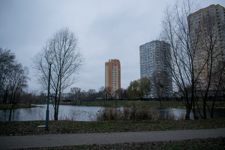 View of the residential area with multi-storey houses near the lake. The weather is dull, evening, autumn.の写真素材