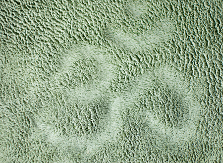 Background of soft gray fabric on which is drawn the sign of Om.の写真素材