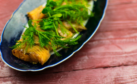 Hot smoked fish in a plate on a Wooden background color "Tawny Port" wooden background.の写真素材