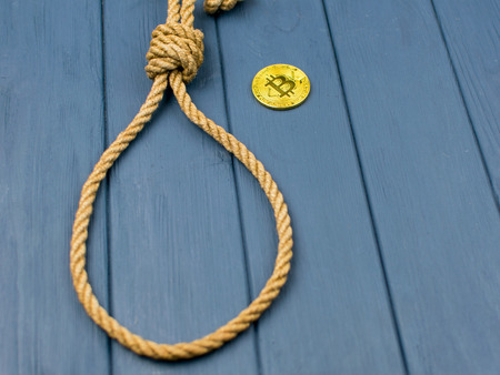 The concept of suicide due to the fall of bitcoin. A loop of rope for the gallows and bitcoin.の写真素材