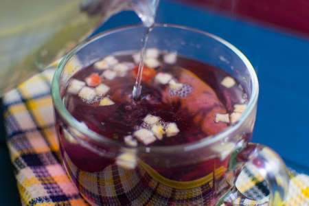 Fruit tea in a glass transparent cup. Topping up hot water in a cup.の写真素材