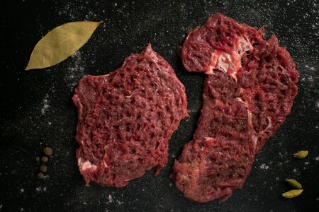 Raw pork chop with spices on a dark background.の写真素材