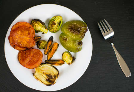 Grilled vegetables on a white plate on a black background.の写真素材