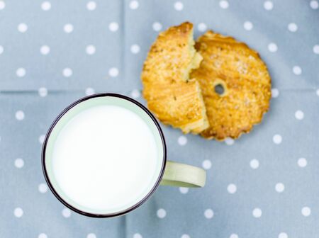 Large cup with milk and cookies in the background.の写真素材
