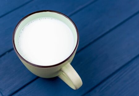 A large cup of milk on a blue background.の写真素材