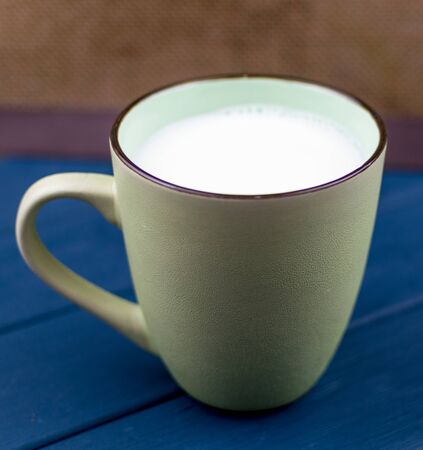 A large cup of milk on a blue background.の写真素材