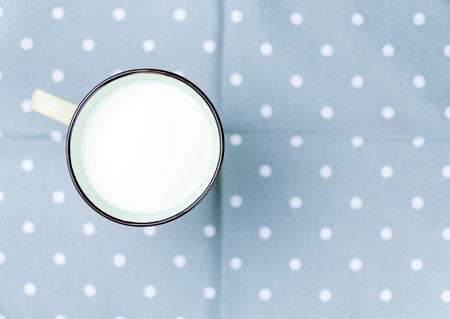 A large cup of milk on the tablecloth.の写真素材