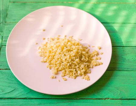 Cooked bulgur on a plate on a green wooden background.の写真素材