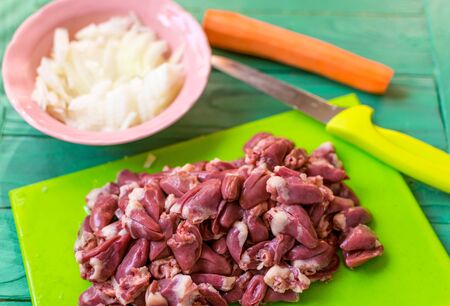 Fresh raw chicken hearts cut for preparation.
