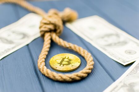 The concept of suicide due to the fall of bitcoin. A loop of rope for the gallows and bitcoin.の写真素材