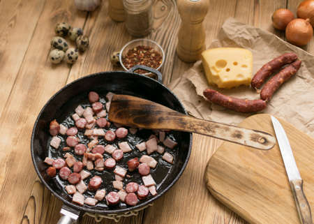 Bavarian sausages are sliced and fried in a frying pan.の写真素材