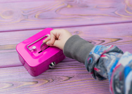 Hand of a child and a piggy bank.の写真素材