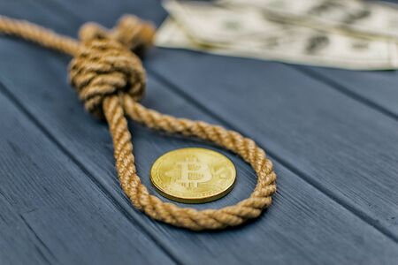 The concept of suicide due to the fall of bitcoin. Rope for the gallows and bitcoin in the photographic processing.の写真素材