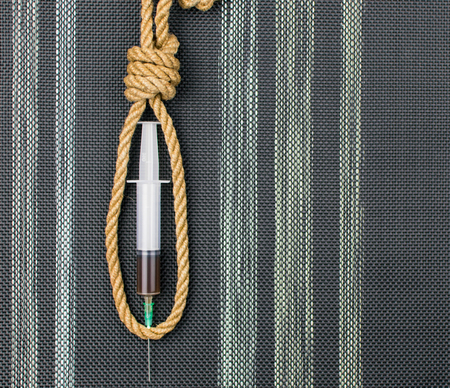 The concept of death from drugs. A syringe in a loop for the gallows.