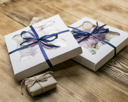 Marshmallow in a gift box on a wooden background. Sweet gift.の写真素材