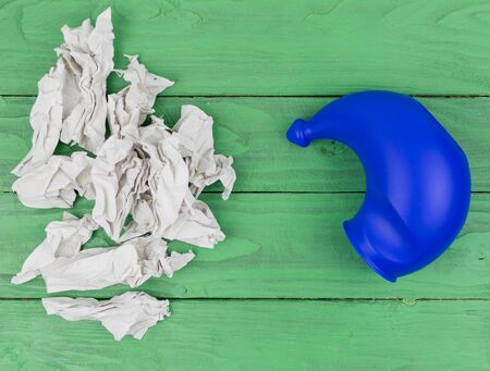 A device for washing the nose and crumpled toilet paper with snot in the background.の写真素材