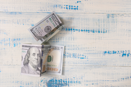 hundred dollar bills on a wooden background.の写真素材