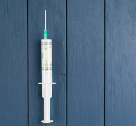 The concept of money and drugs. A hundred dollars in a syringe.の写真素材