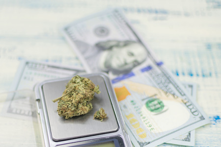 Sale, weighing of marijuana. Bud of marijuana on a jewelry scales against the background of dollars.の写真素材