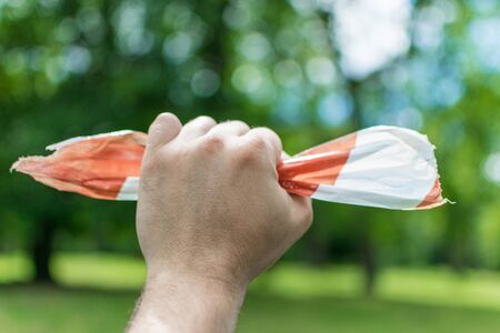 Restrictive tape. The severed part of the tape in the man's hand. The concept of violation of...