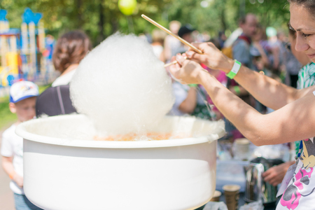 Kiev, Ukraine, -07 July, 2018: The girl makes sweet cotton wool in the city park.のeditorial素材