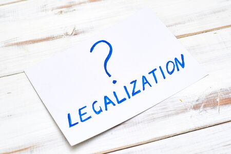 Legalization word with a question mark on a light wooden background.の写真素材
