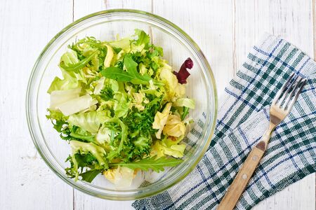 Vegetarian salad mix of fresh vegetables on a light wooden background. Healthy and wholesome organic food, diet, proper nutrition concept.の写真素材