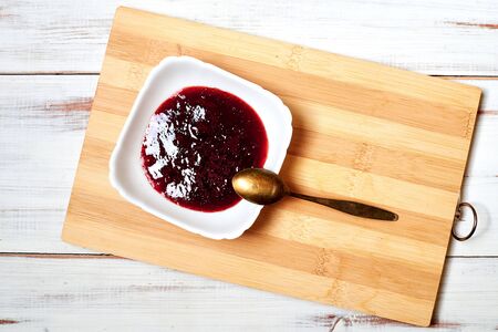 Strawberry jam on a light wooden background.の写真素材