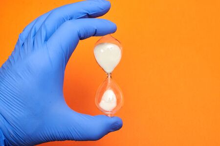 Hourglass in the doctor's hand. Medicine and time concept.の写真素材