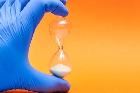Hourglass in the doctor's hand. Medicine and time concept.の写真素材