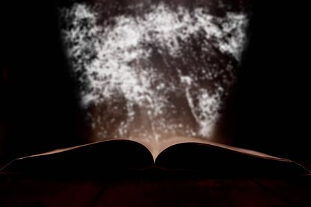 An open book with a glow in the background.