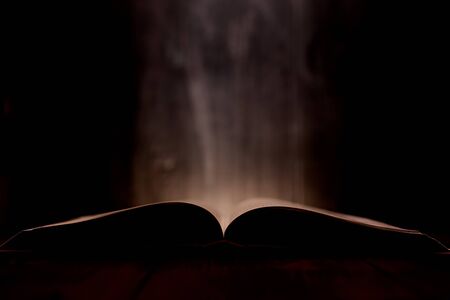 An open book with a glow in the background.
