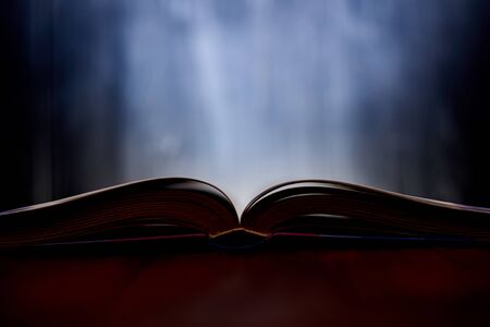 An open book with a glow in the background.