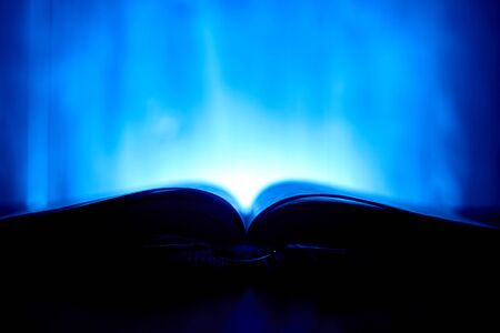 An open book with a glow in the background.の写真素材