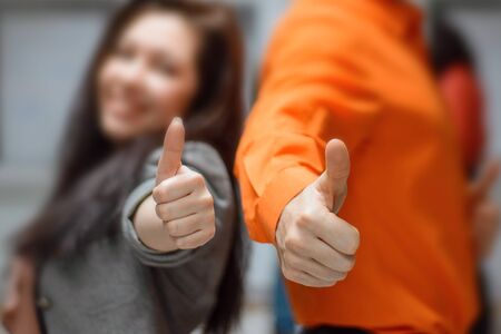 Man and woman hold thumbs up.の写真素材