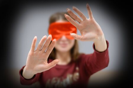 The girl comes with a blindfolded eyes blindly to the touch.の写真素材