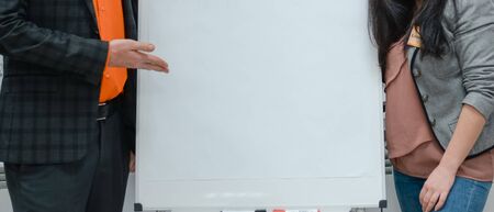 A man and a woman show on a white board.