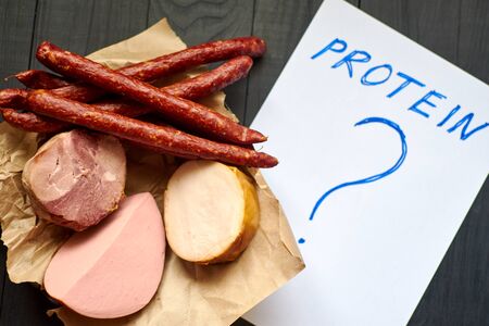 Protein and question mark and different sausages and sausages. Unhealthy eating concept.の写真素材