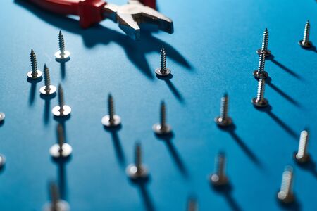 Screws and pliers on a blue background.の写真素材