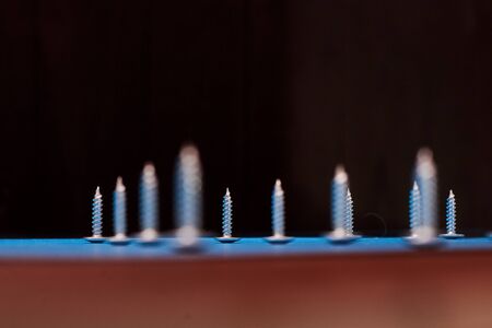 Screws in a row on a blue background.